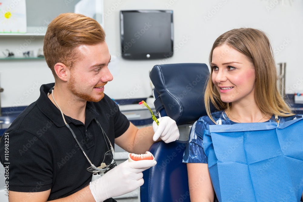 Doctor Counseling patient about how to clean teeth with a toothbrush Doctor Counseling patient about how to clean teeth with a toothbrush