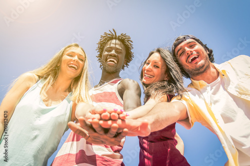 Group of multiracial friends smiling with hands in stack photo