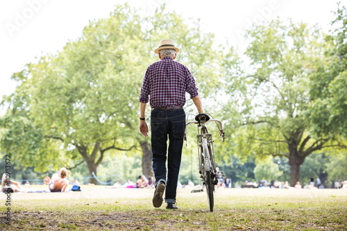 Senior man with bicycle in park, Hackney, London