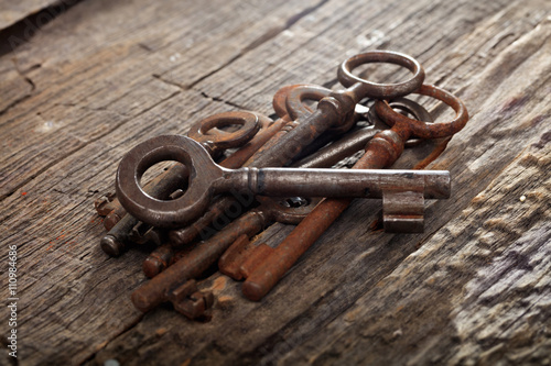 Bunch of rusty old keys on wooden surface