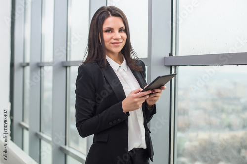 business woman standing at window with tablet © naataali
