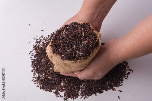 raw rice in hands holding on white background photo