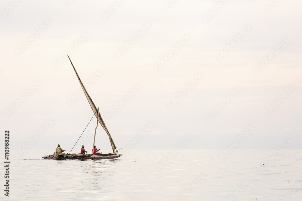 Traditional fisherman boat in Zanzibar on ocean with rainy cloud