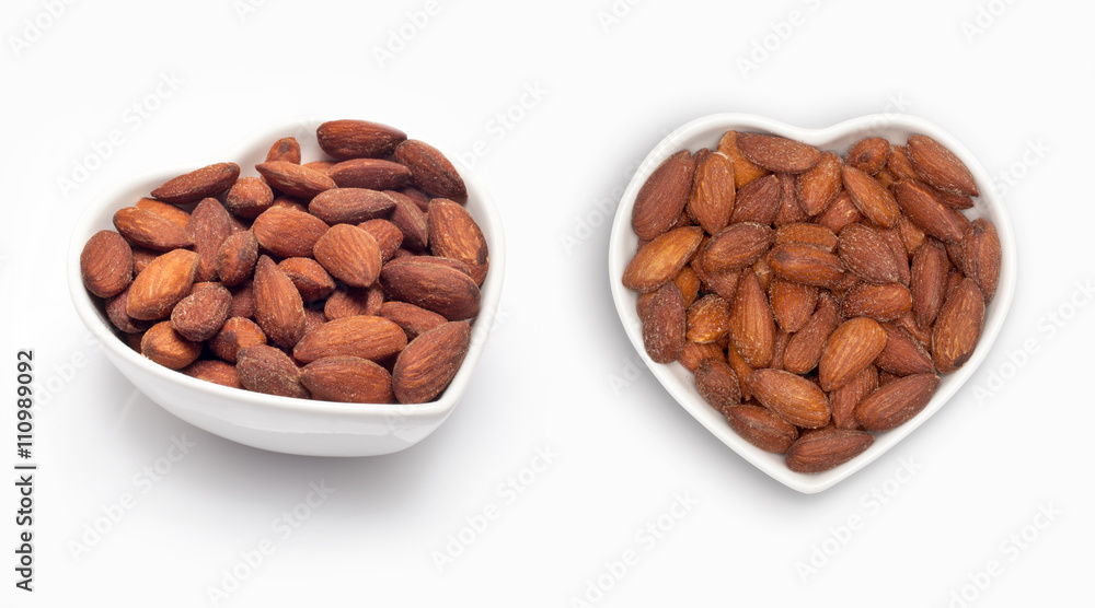 Almonds in a heart shaped bowl, isolated on white Almonds in a heart shaped bowl, isolated on white