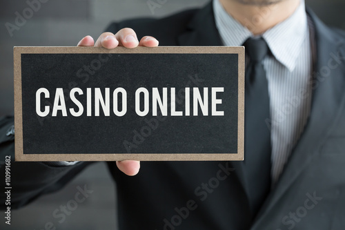 Casino online, message on blackboard and hold by businessman