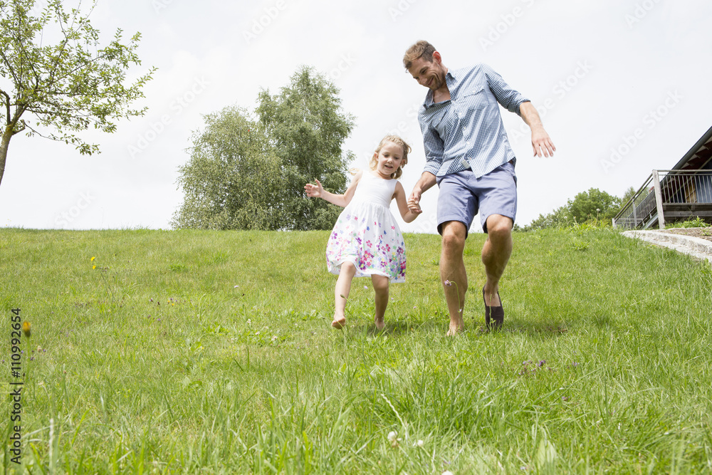 Father and daughter running downhill Father and daughter running downhill