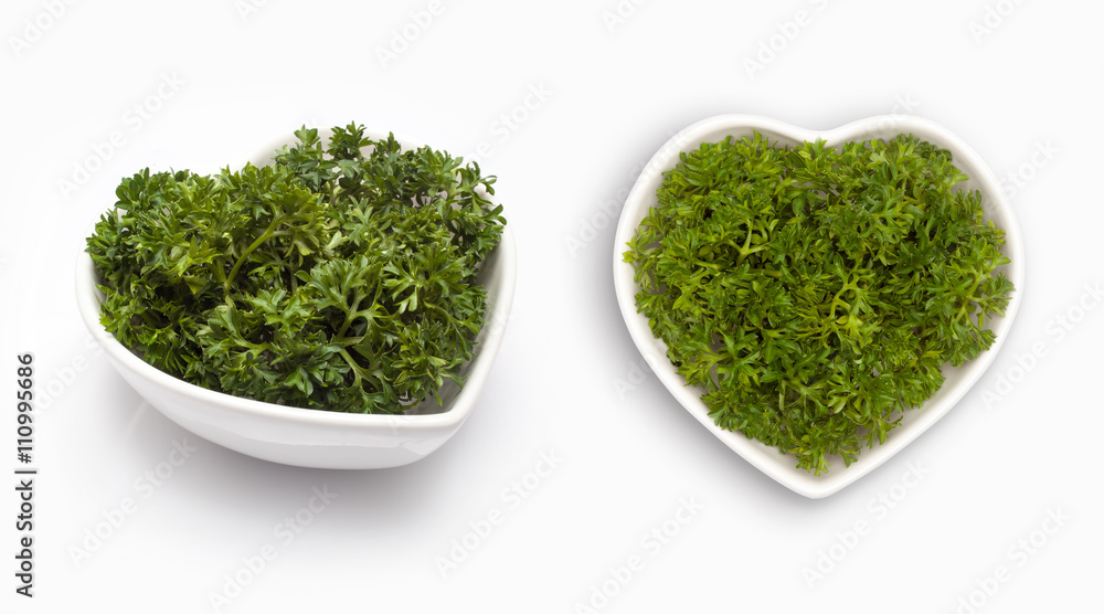Fresh parsley in a heart shaped bowl, isolated on white Fresh parsley in a heart shaped bowl, isolated on white