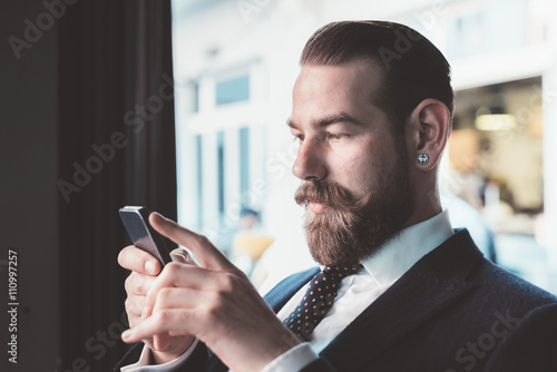 Businessman reading smartphone update in cafe