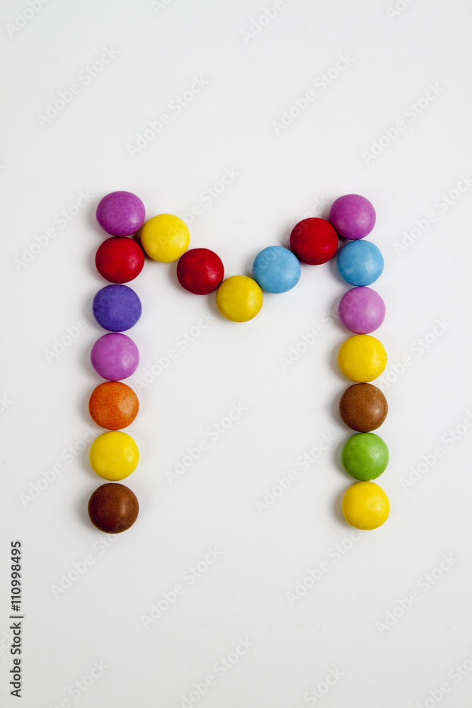 La lettera M formata da coloratissimi confetti di cioccolato.