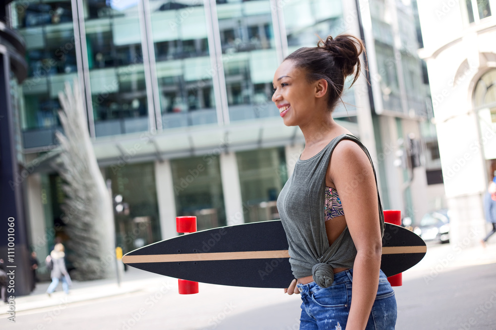 city girl in the street holding her longboard