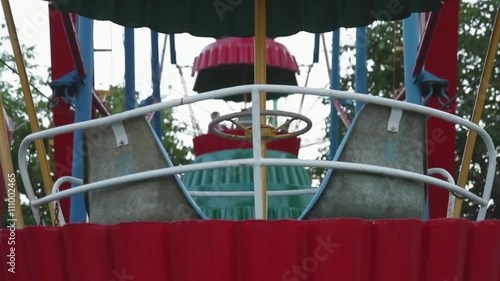 Moving colorful cabins of observation wheel. Amusement park. Trees and clear sky at sunset. photo