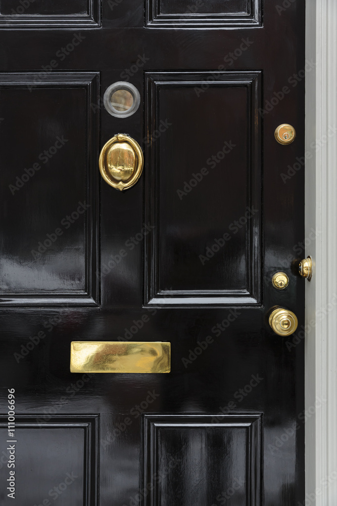 Naklejka premium Front door, black close up with brass fixtures