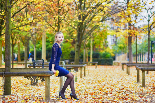 Beautiful young woman in the Luxembourg garden of Paris on a fall day