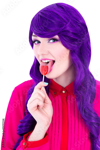 portrait of woman with purple hair wig licking lollipop isolated