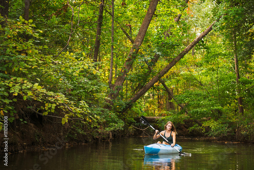 Young woman kayaking on river in forest, Cary, North Carolina, USA