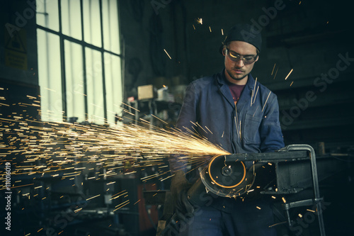 Welder cutting iron in workshop photo