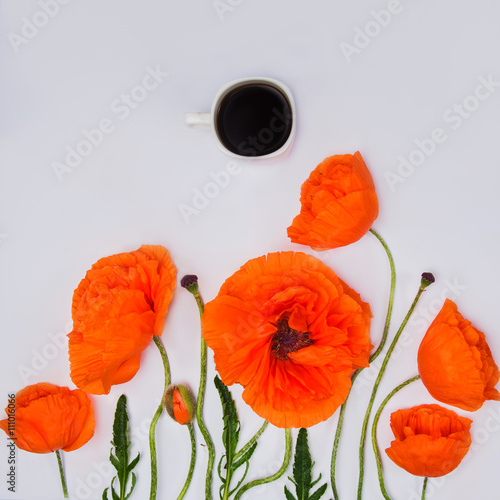 Cup of coffee and poppy flowers on a light gray background. applied toning