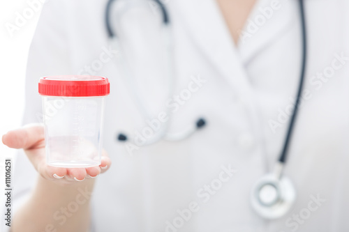 View of hand of nurse holding empty test container