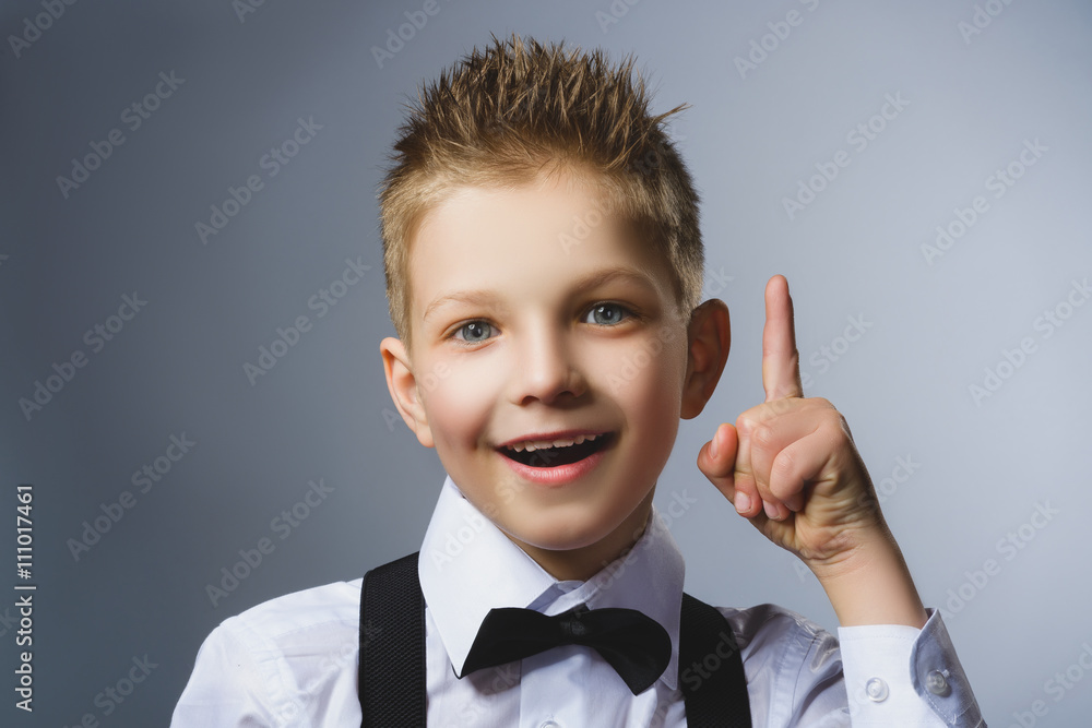 Closeup Portrait of gestured child on grey background. Boy found the idea or solution Closeup Portrait of gestured child on grey background. Boy found the idea or solution