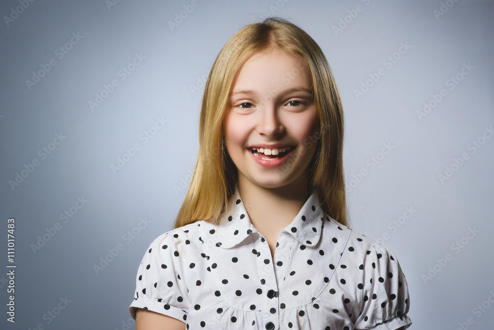 Happy girl. Closeup Portrait of handsome teen in casual shirt smiling while standing against grey background Happy girl. Closeup Portrait of handsome teen in casual shirt smiling while standing against grey background