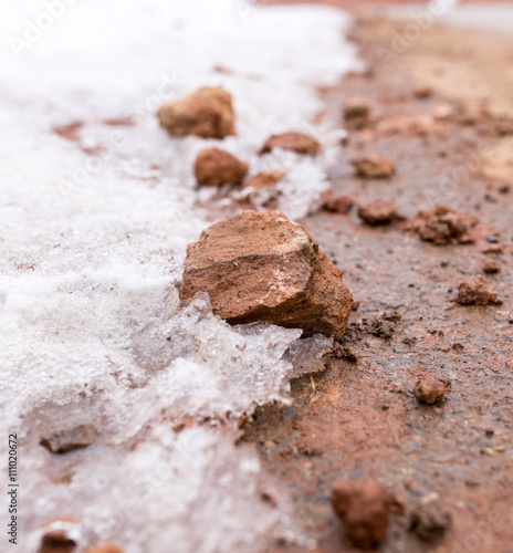 snow on red clay in nature