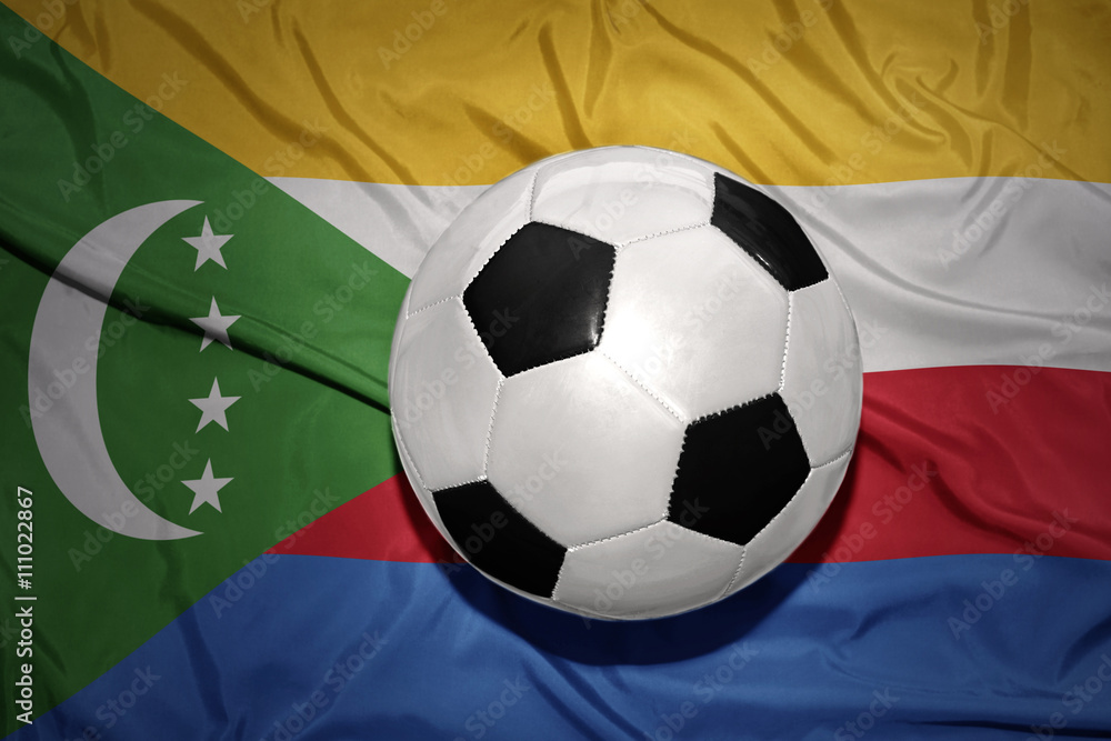 Naklejka premium black and white football ball on the national flag of comoros