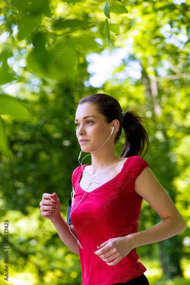 Sporty young woman running in the park and listening to music. Sport lifestyle. Sporty young woman running in the park and listening to music. Sport lifestyle.