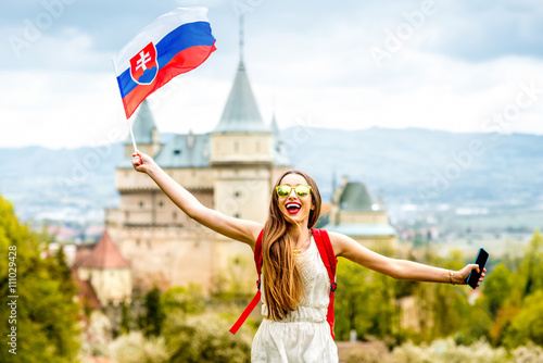 Wallpaper Mural Young female tourist having fun traveling with slovak flag at Bojnice castle in Slovakia