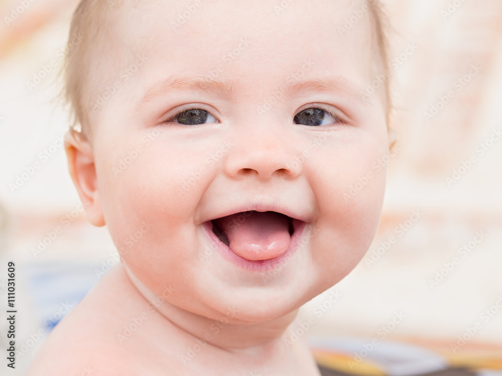 Portrait of cute little toddler shows tongue.