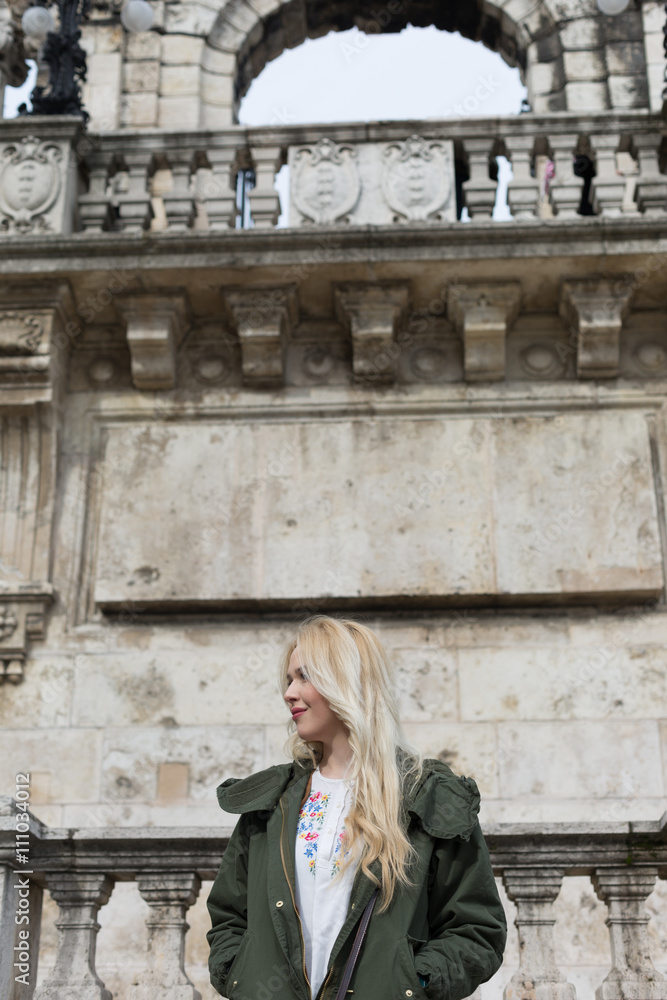 Beautiful blonde woman in a front of marvelous arcitecture