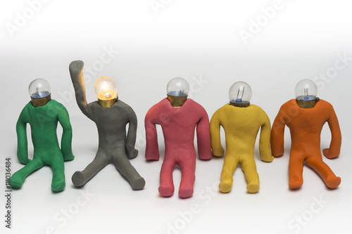 Clay figures with bulb head seated on floor, having an idea
