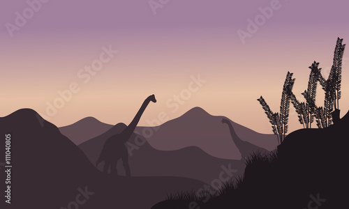Silhouette of two brachiosaurus in fields