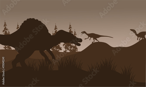 Silhouete of spinosaurus and eoraptor in hills