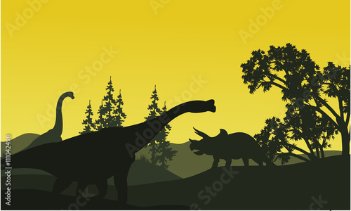 At moorning triceratops and brachiosaurus silhouette in fields © wongsalam77