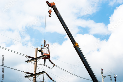 technician works in a bucket high up on a power pole