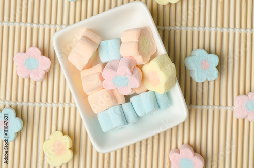 Colorful marshmallows (flower shape) on white plate
