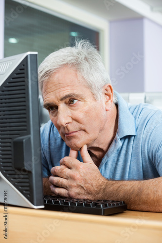 Tensed Senior Man Looking At Computer In Class