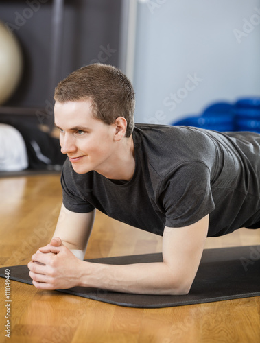 Young Man Performing Plank Position In Gym