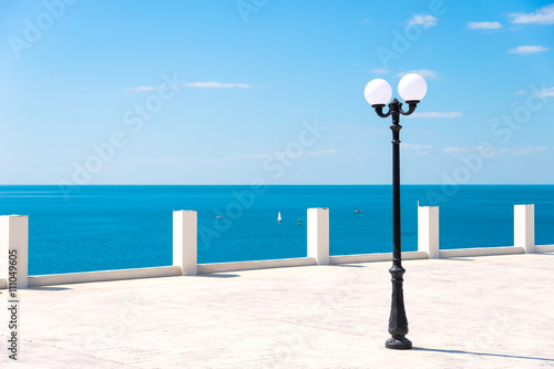 Street lamp on the sea promenade on clear sunny day photo