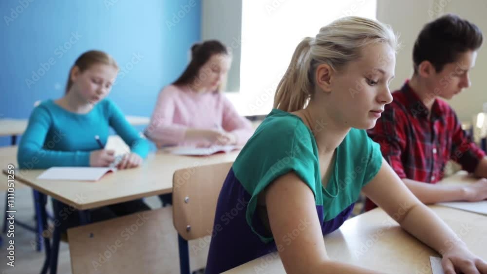 students with notebooks writing test at school students with notebooks writing test at school