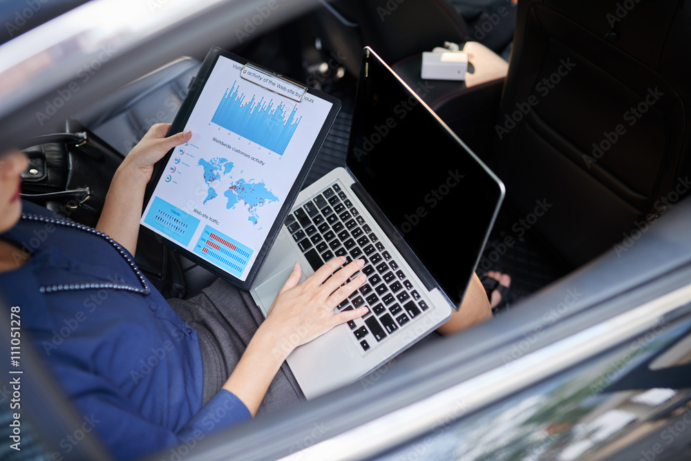 Fototapeta premium Business woman working with diagram in car