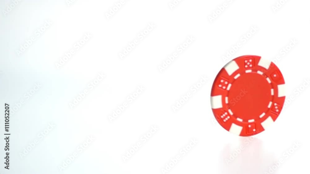 red poker chip turning on white surface close up in slow motion red poker chip turning on white surface close up in slow motion