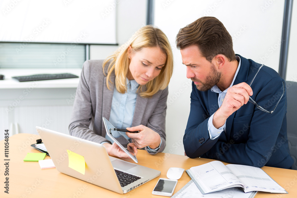 Businessman and his assistant working together at the office Businessman and his assistant working together at the office