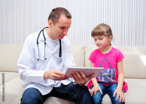 Doctor with girl looking at tablet