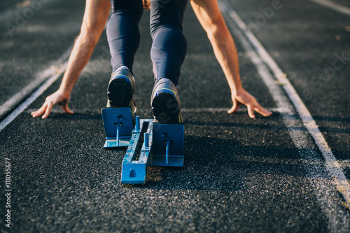 Detailed view of a sprinter getting ready to start. Selective focus.