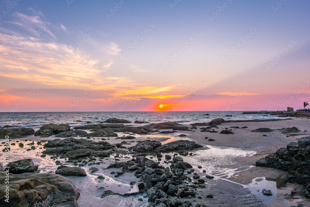 Sea , sand and rocks at the sunset.