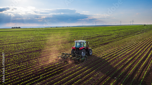 Tractor cultivating field at spring photo