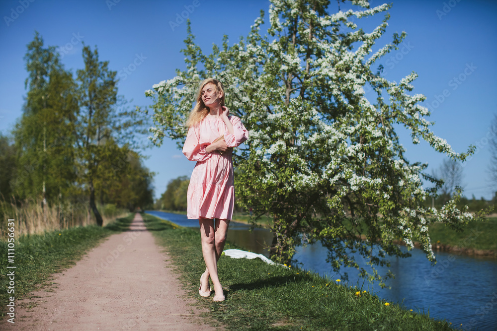 beautiful girl in dress standing with diary under the apple blossom beautiful girl in dress standing with diary under the apple blossom