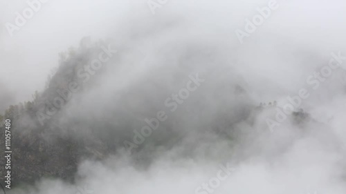 Russia. In early spring the dense veil of mist and clouds creeping up the steep mountain slopes of the Central Caucasus peaks.