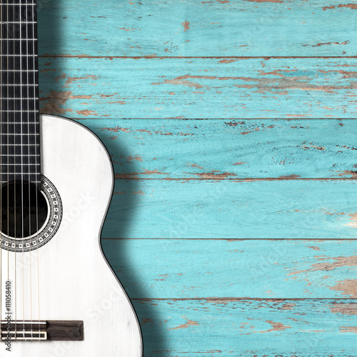 White classical guitar on vintage wood background with copy space.